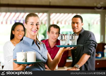 Woman as waitress in a bar or restaurant with coffee mugs; in the background are guests