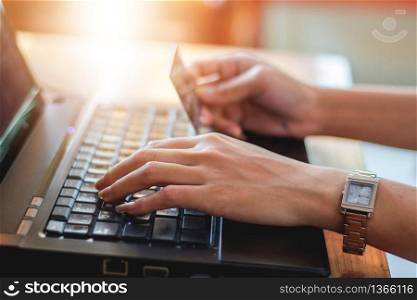 woman asian using laptop and credit card shopping online , selective focus on hand,soft focus and vintage tone