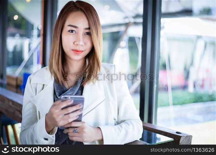 woman asian using phone for shopping online and calling with cell telephone in coffee shop during free time