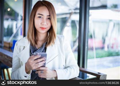 woman asian using phone for shopping online and calling with cell telephone in coffee shop during free time