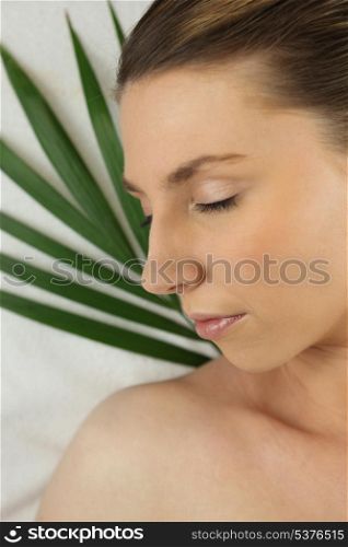 Woman asleep against a green plant
