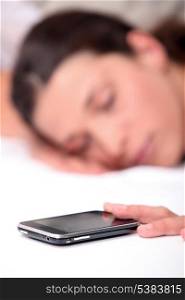 Woman asleep next to mobile telephone