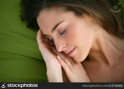 Woman asleep on a green pillow