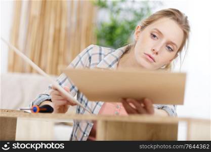 woman assembling furniture at home