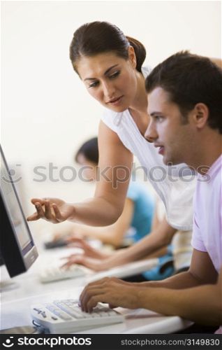 Woman assisting man in computer room