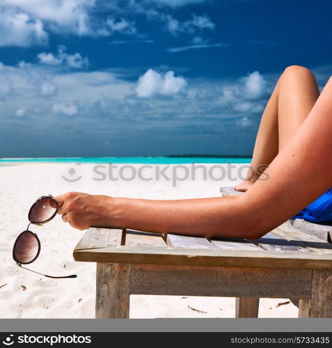 Woman at beautiful beach holding sunglasses