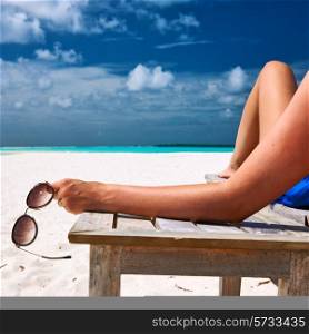 Woman at beautiful beach holding sunglasses