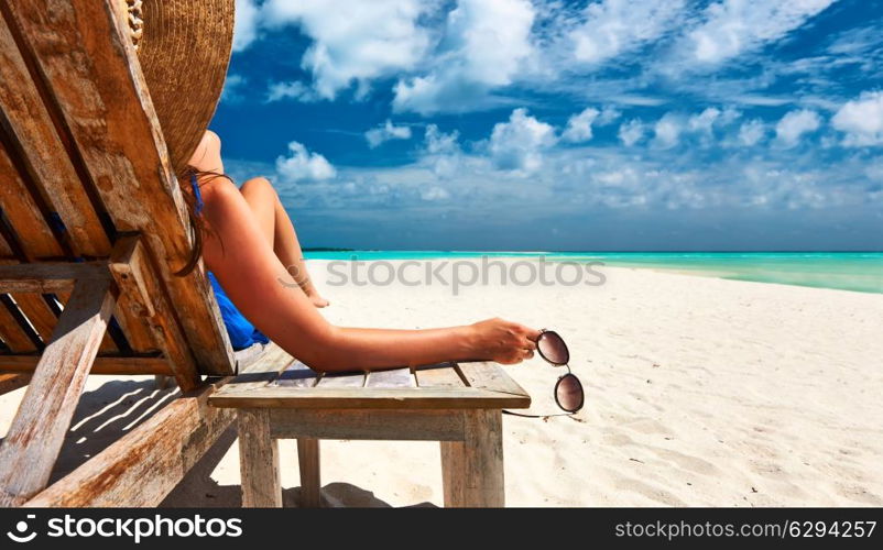 Woman at beautiful beach holding sunglasses