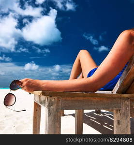 Woman at beautiful beach holding sunglasses