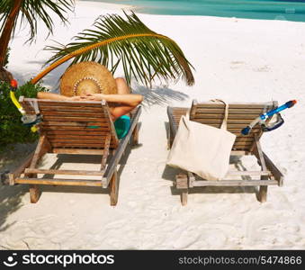 Woman at beautiful beach with chaise-lounges