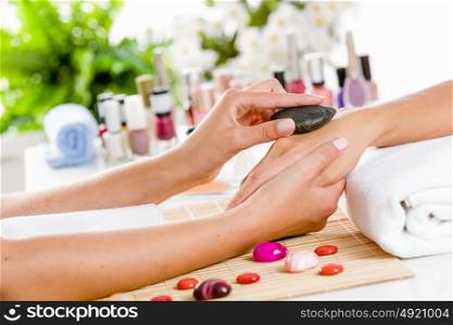 Woman at beauty salon. Close up of process of hand massage at beauty salon