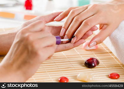 Woman at beauty salon. Close up of process of manicure at beauty salon