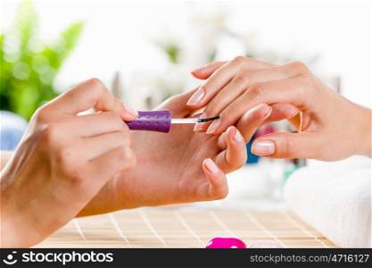 Woman at beauty salon. Close up of process of manicure at beauty salon