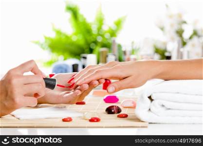 Woman at beauty salon. Close up of process of manicure at beauty salon