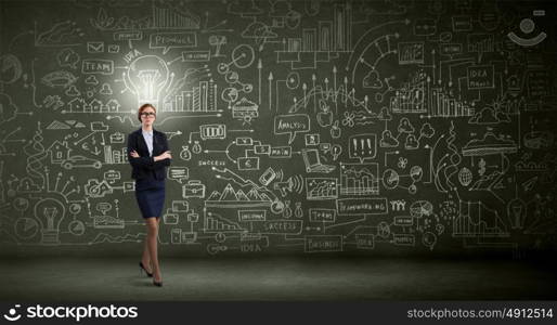 Woman at blackboard. Young confident woman wearing glasses standing near blackboard