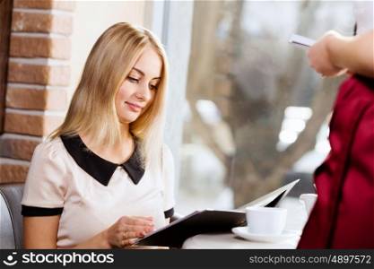 Woman at cafe. Young attractive woman making order at restaurant