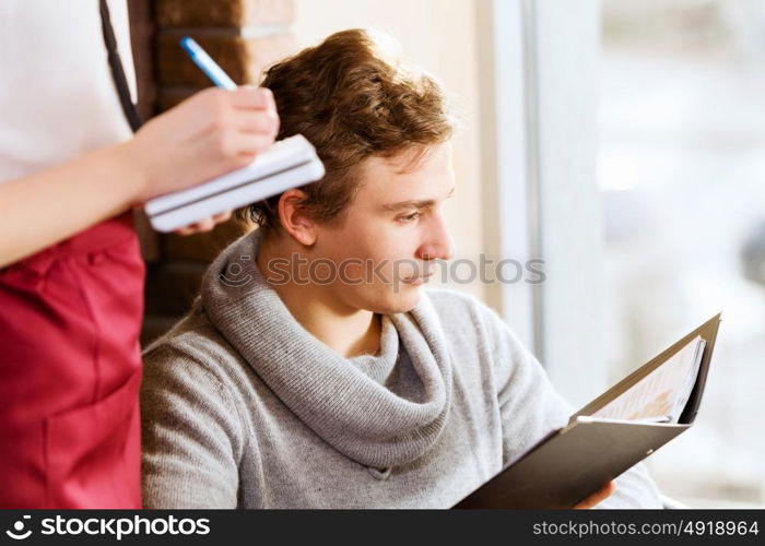 Woman at cafe. Young attractive woman making order at restaurant