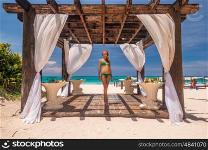 Woman at caribbean beach with pergola (gazebo) in Dominican Republic