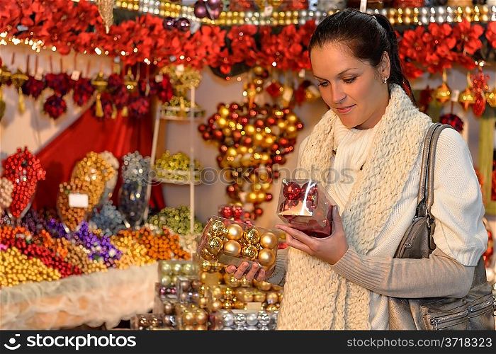 Woman at christmas decoration shop holding boxes of Xmas balls