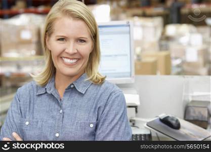 Woman At Computer Terminal In Distribution Warehouse