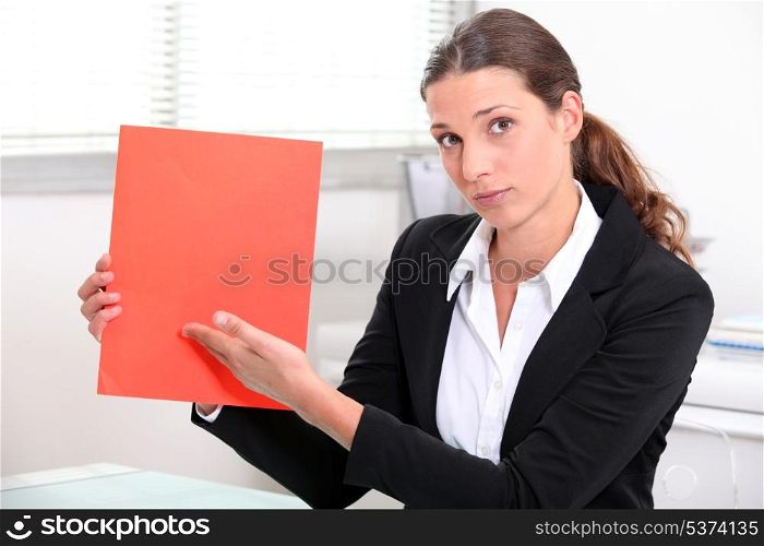 Woman at desk showing document