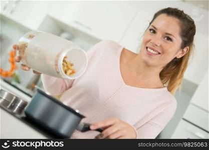woman at home cooking pasta