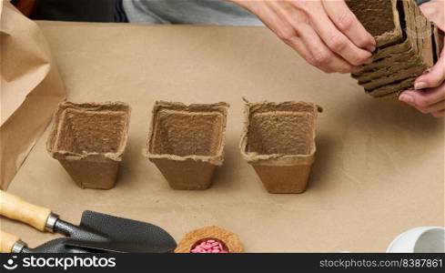 Woman at home holding paper cups for planting plants and vegetables. Hobby and leisure