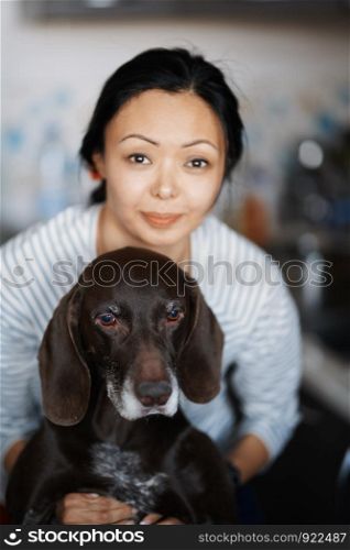 Woman at home hugging her dog