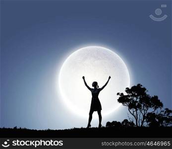 Woman at night. Silhouette of woman against full moon with hands up