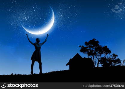 Woman at night. Silhouette of woman against moon with hands up