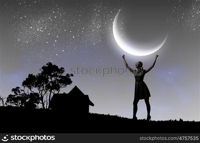 Woman at night. Silhouette of woman against moon with hands up