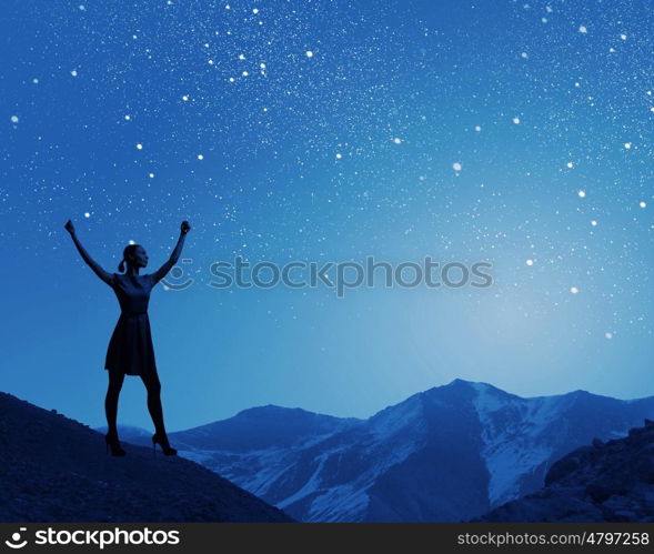 Woman at night. Silhouette of woman in dress at night with hands up