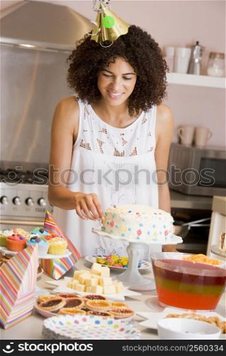 Woman at party fixing cake on table smiling