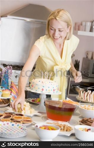 Woman at party getting tart from food table smiling