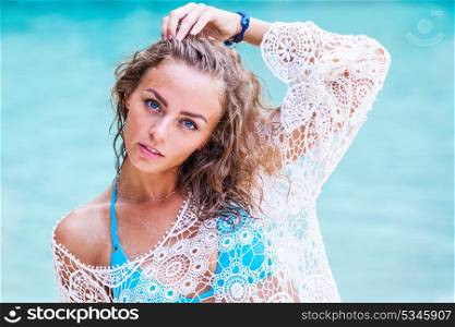Woman at sea beach. Beautiful young woman in bikini posing at sea beach