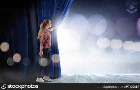 Woman at stage. Young woman in casual opening blue curtain