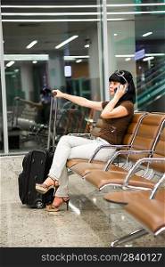 Woman at the airport calling on mobile phone