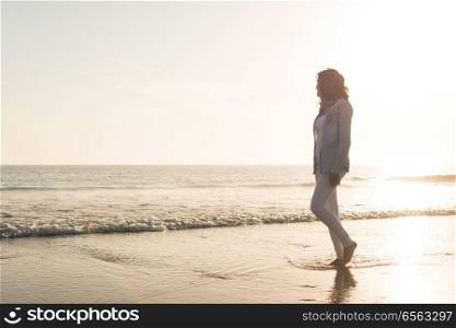 Woman at the beach. Beautiful woman enjoying sunset at the beach