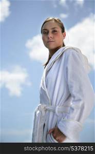Woman at the beach wearing white robe