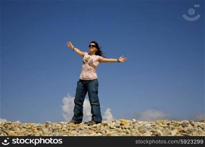 woman at the beach with open arms and the sky