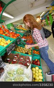Woman at the grocery store buying fruits and vegetables