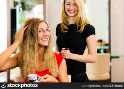 Woman at the hairdresser getting advise on her hair styling, the girls are drinking Cappuccino