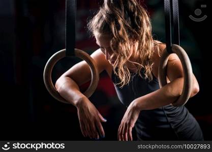 Woman athlete exercising on gymnastic rings