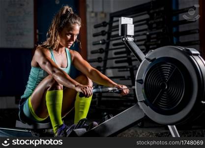 Woman athlete exercising on rowing machine