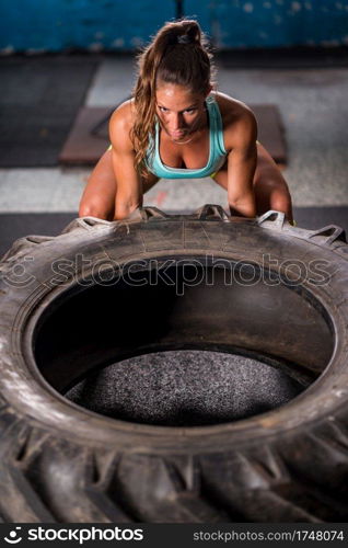 Woman athlete exercising with tire