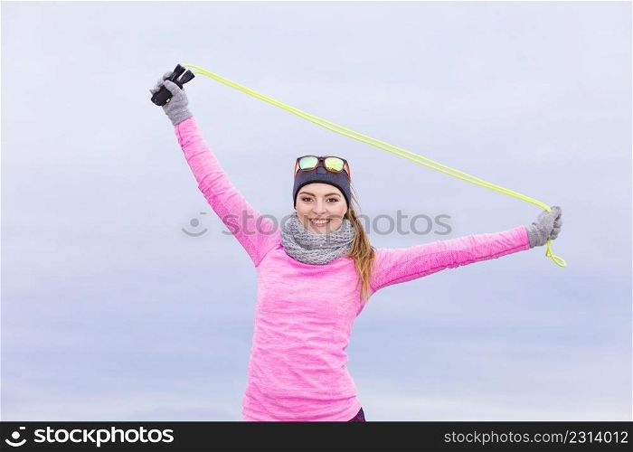 Woman athlete fit girl training outdoor with jumping skipping rope wearing warm sporty clothes in cold day. Sports activity in winter or autumn time, healthy lifestyle concept. Woman training outdoor with jump rope on cold day