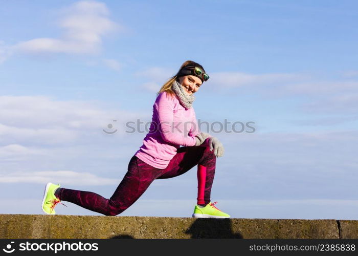 Woman athlete girl training wearing warm sporty clothes outside by seaside in cold weather. Sports and activities in winter or autumn time.. Woman fitness sport girl training outdoor in cold weather