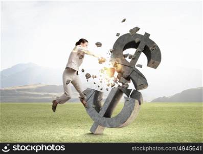 Woman attacking dollar symbol. Determined businesswoman in anger breaking stone dollar sign