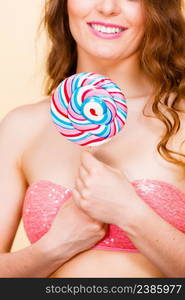 Woman attractive cheerful girl holding big lollipop candy in hand. Sweet food and enjoying concept. Studio shot bright background. Woman holding colorful lollipop candy in hand.