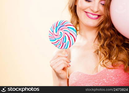 Woman attractive cheerful girl holding big lollipop candy in hand. Sweet food and enjoying concept. Studio shot bright background. Woman holding colorful lollipop candy in hand.